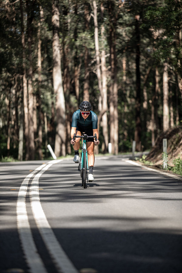 Cyclist riding through tree-lined Melbourne road