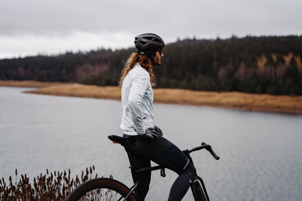 Cyclist beside a foggy lake in a SOOMOM wind jacket and thermal bib tights