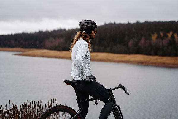 Cyclist beside a foggy lake in a SOOMOM wind jacket and thermal bib tights