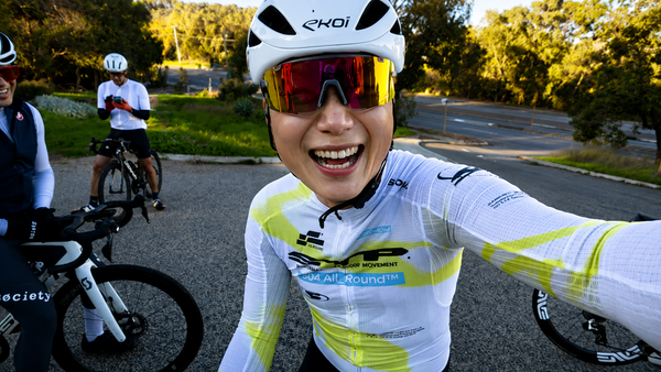 Nat Tan riding on a Perth street, wearing the SOOMOM All-Round OFF STP LS Jersey in Hyperlime, morning sun overhead